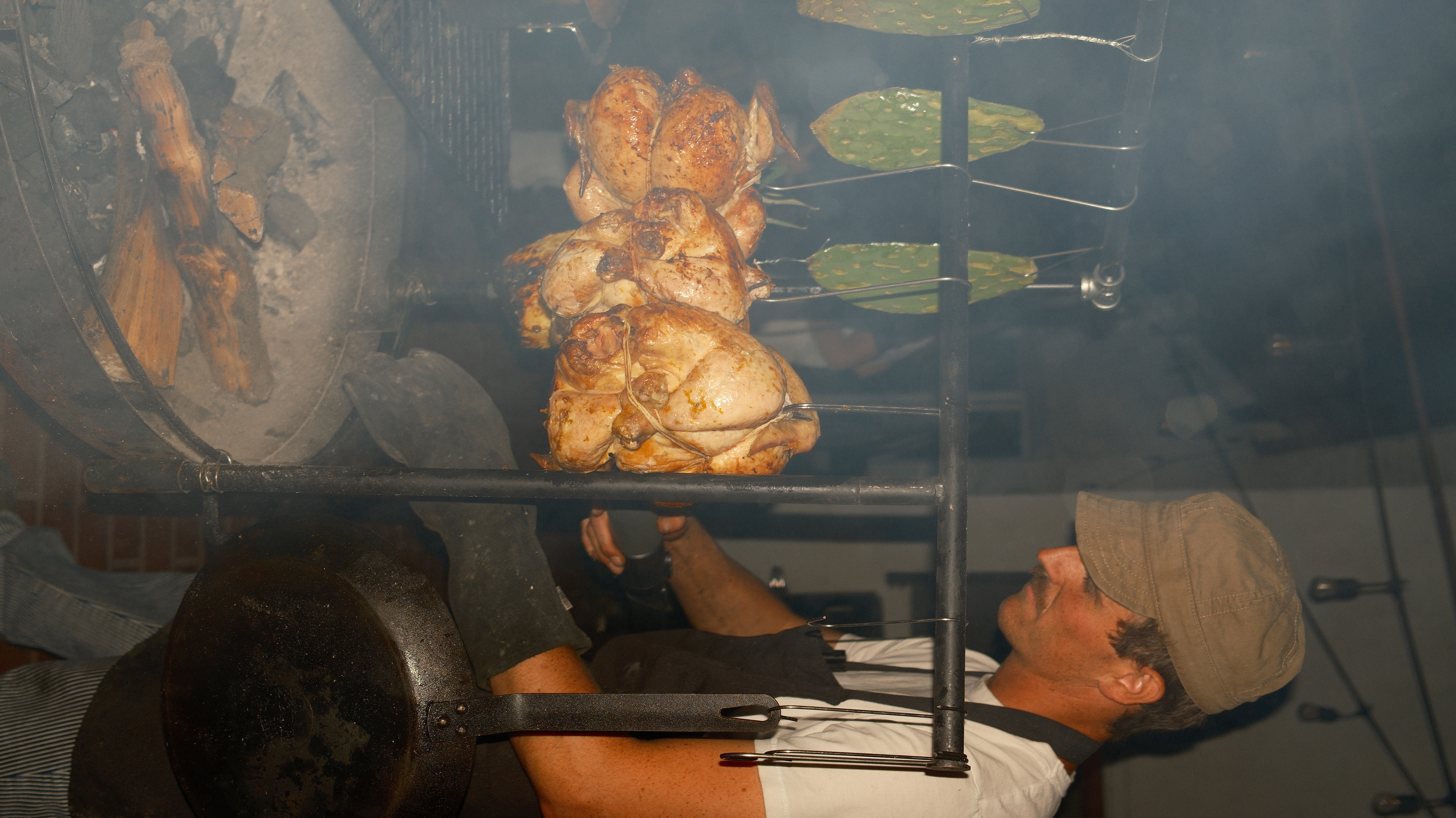 Zack tending hanging chickens over the live fire