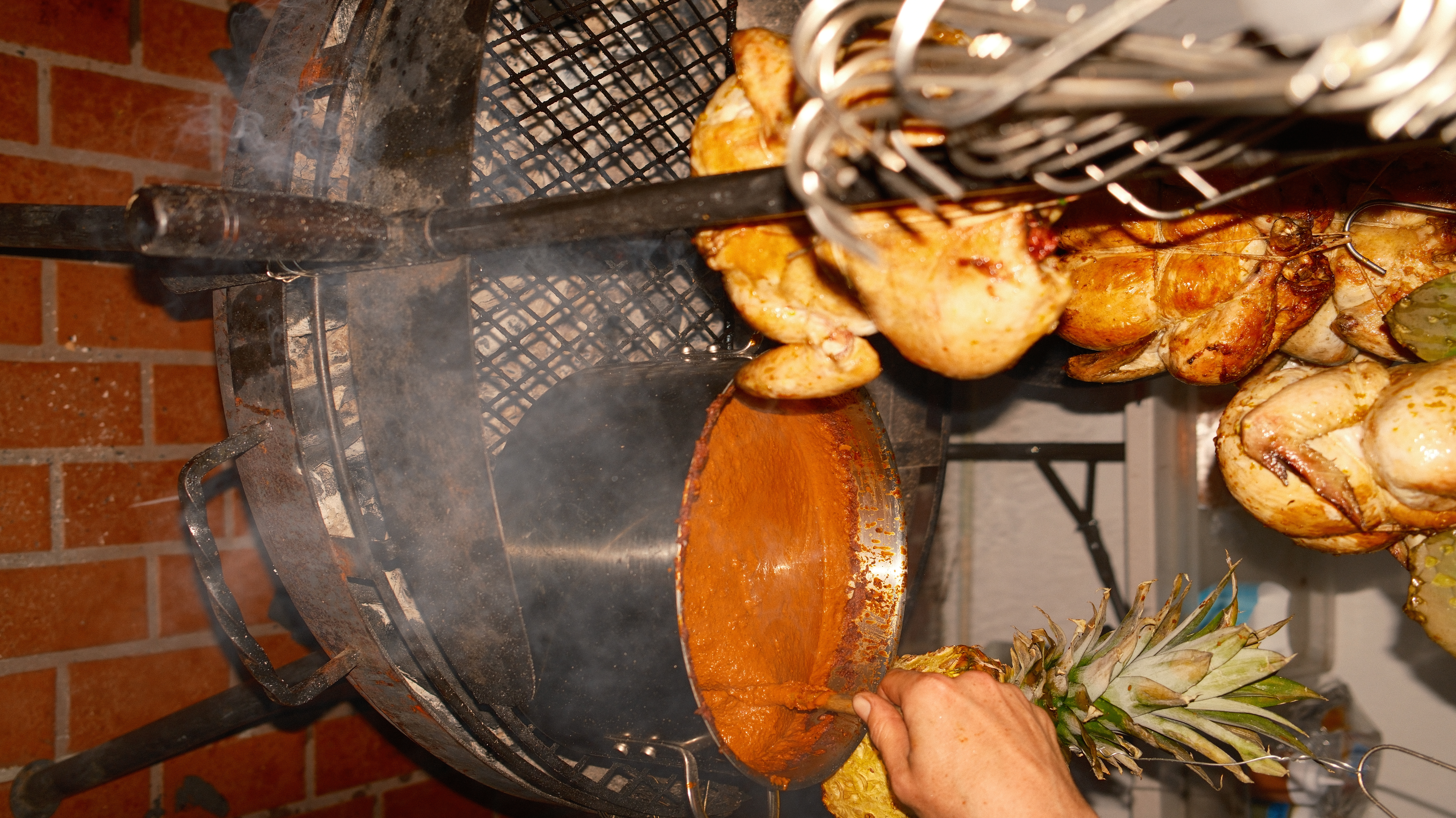 Pineapple, hanging chickens, smoke, and sauce at the fire rig
