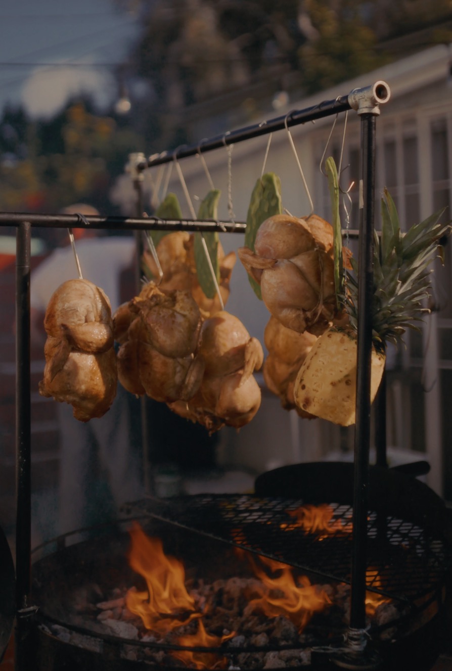 Chickens and pineapple roasting over a hardwood fire