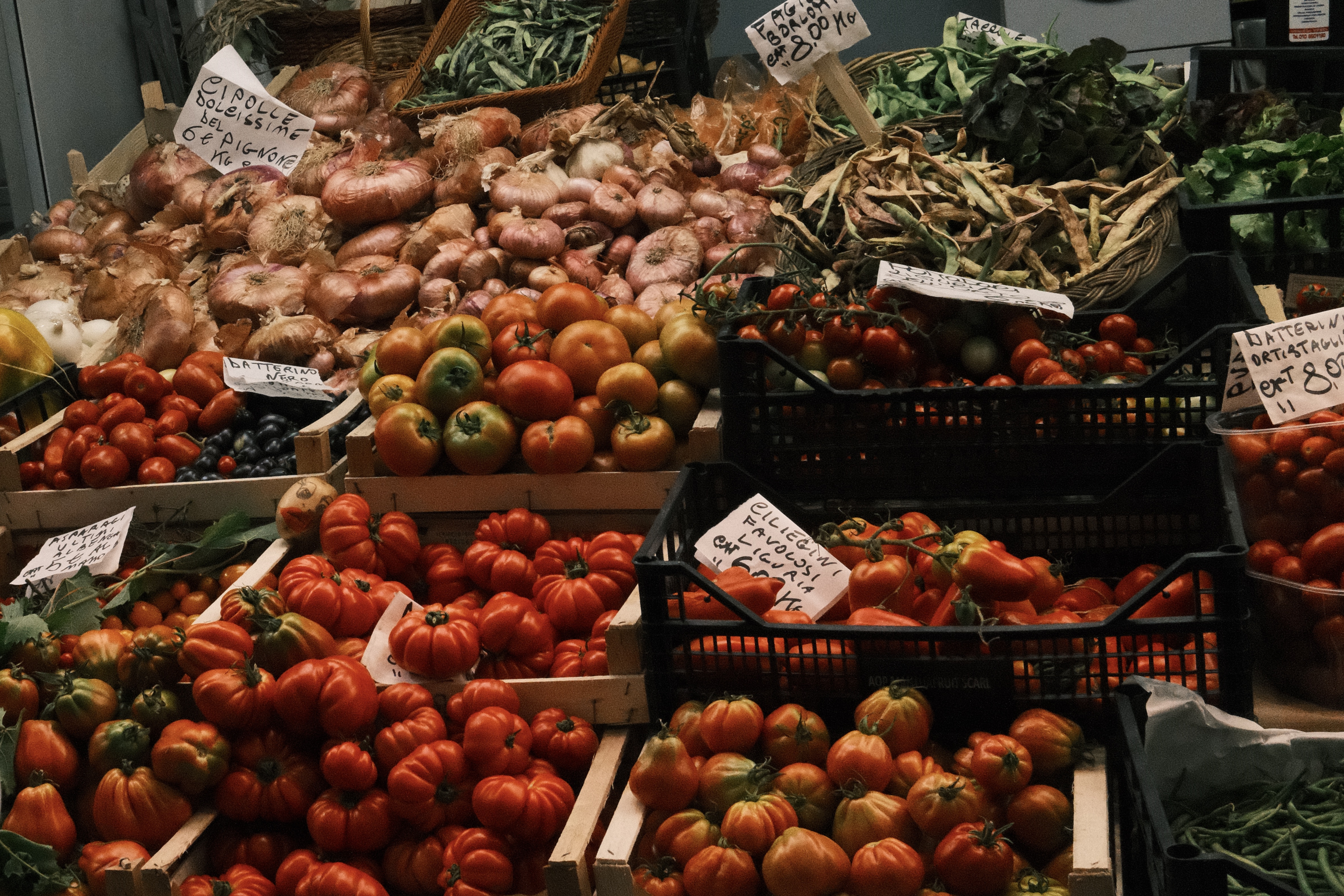 Seasonal tomatoes and produce displayed at a Mediterranean market