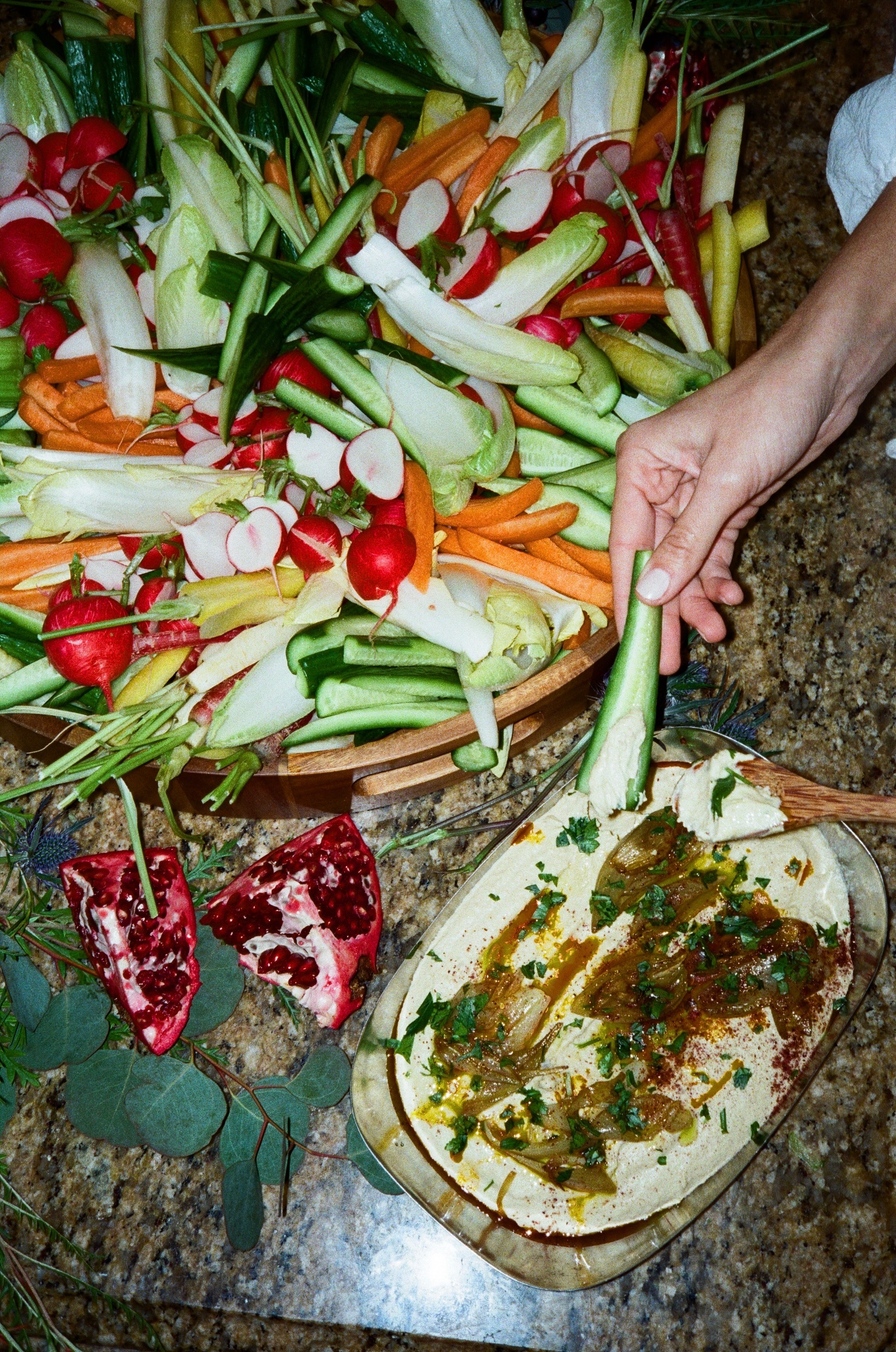 Seasonal vegetables, pomegranate, and dips arranged for an event