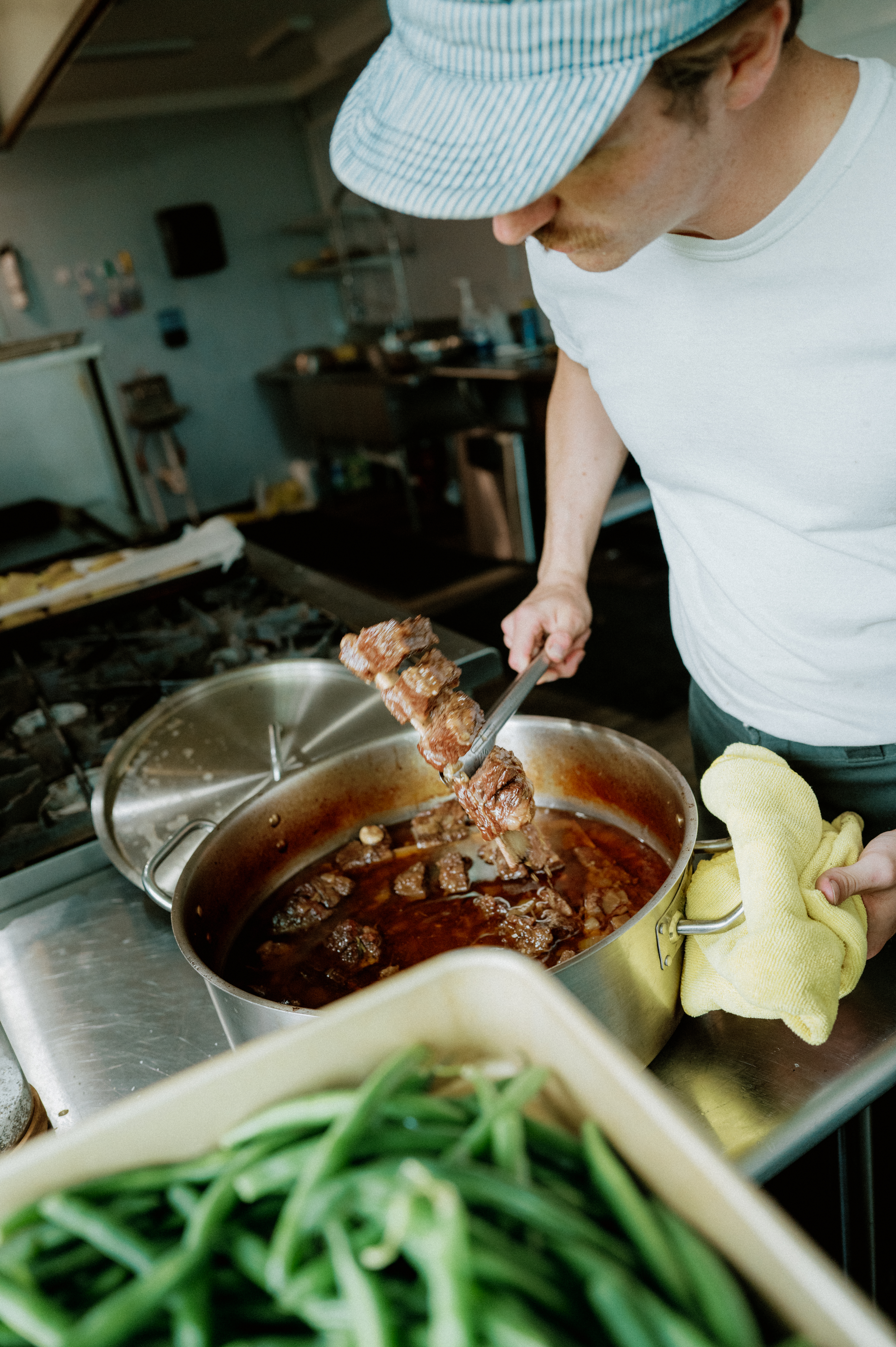 Zack lifting braised short rib from the pot